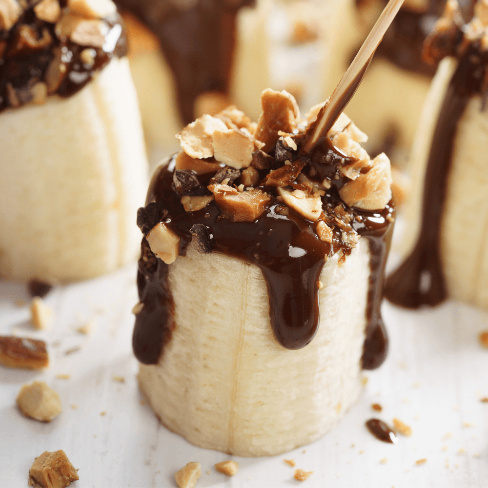 banana with chocolate drizzle and sprinkle of nuts